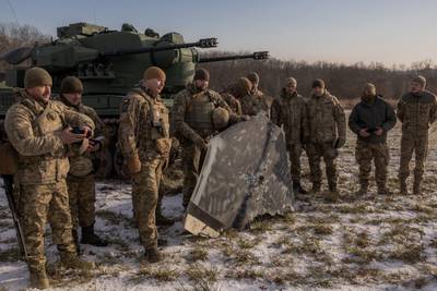 Ukrainian servicemembers pose for a photo holding a reportedly Russian-launched drone on the outskirts of Kyiv on Nov. 30, 2023.