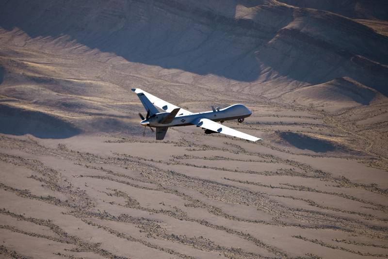 A drone flies over the desert.