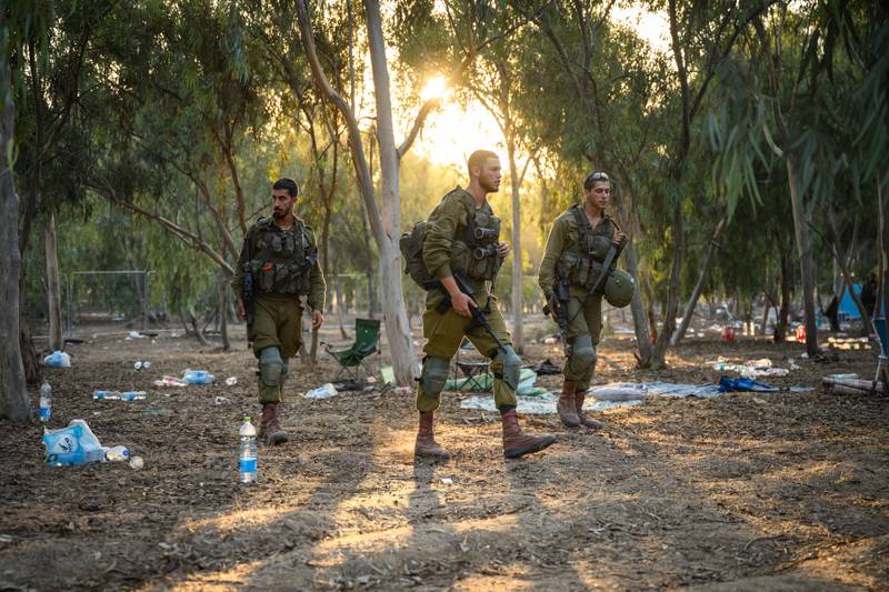 Troops search for identification and personal effects at the Supernova Music Festival site, where hundreds were killed and dozens taken by Hamas militants in October.