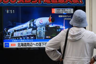A woman in Tokyo, Japan, watches a television broadcasting breaking news of a North Korean missile launch.