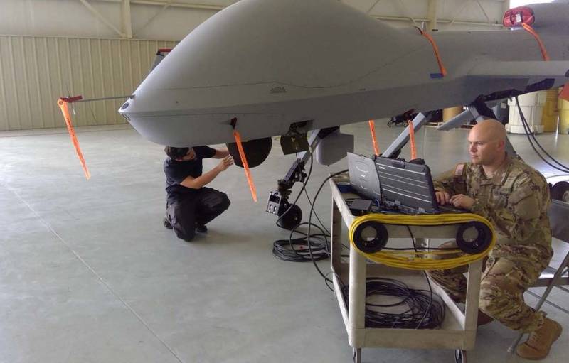 An MQ-1C Gray Eagle maintainer (15M) and an Army field service representative work together to evaluate a Common Sensor Payload at Fort Bliss, Texas.