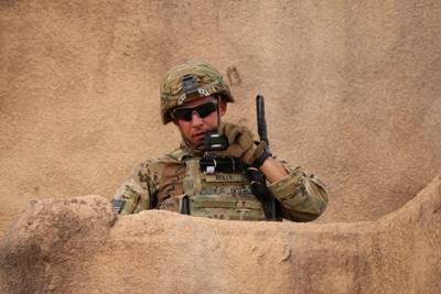 U.S. Army Cpl. Tyler Reilly, an infantryman, radios in his situation report after clearing a mock building during training in 2018 at Fort Bliss, Texas.