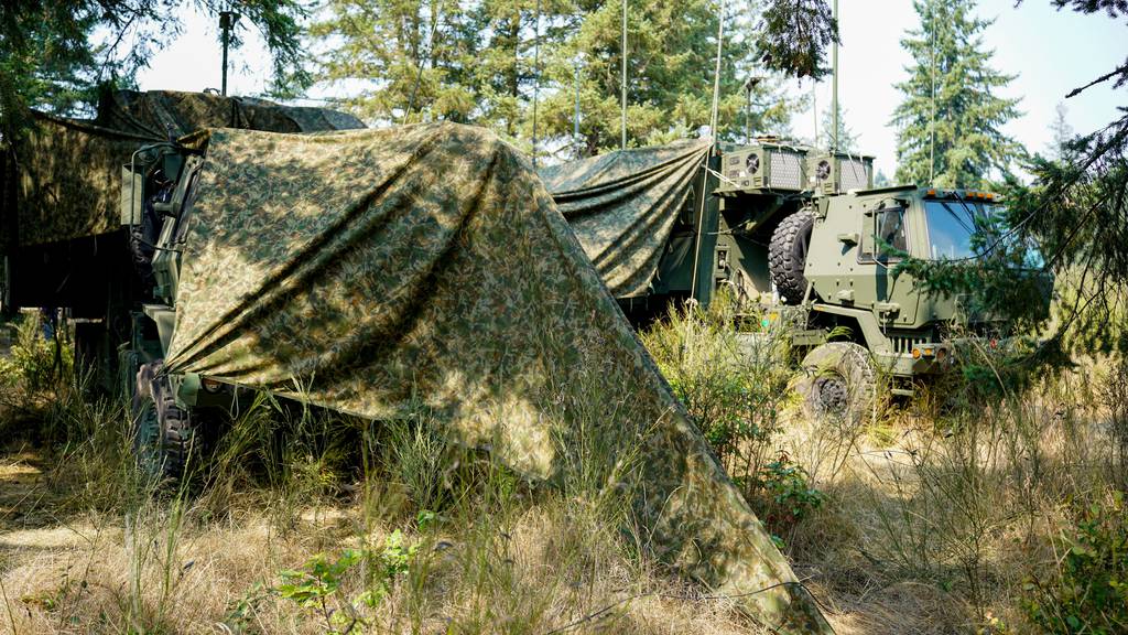 Camouflaged mobile command post vehicles blend in during a CPI2 limited user test at Joint Base Lewis-McChord, Washington, on August 21, 2023.
