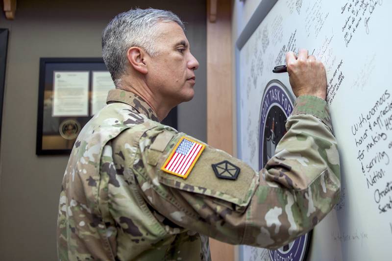 U.S. Army Gen. Paul Nakasone, commander of U.S. Cyber Command and director of the National Security Agency, signs the Joint Task Force-Space Defense’s board during his visit to the organization at Schriever Space Force Base, Colorado, in July 2022.