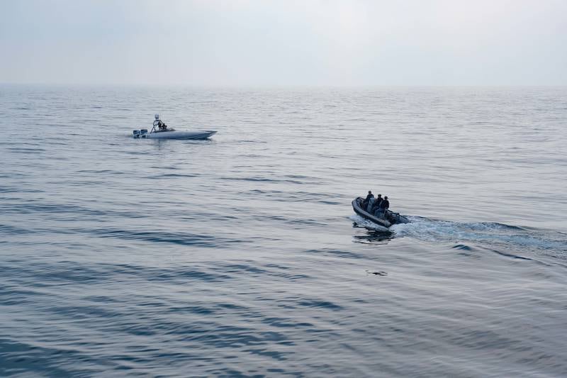 Members of Combined Task Force 152 operate a small boat near a MARTAC T-38 Devil Ray unmanned surface vessel in the Arabian Gulf.