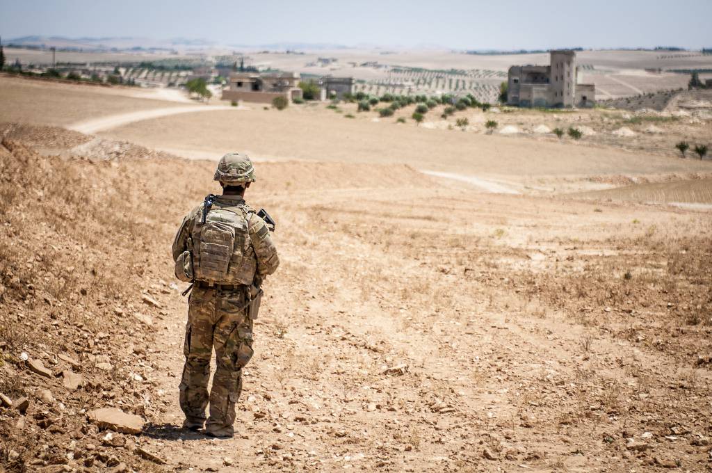 A U.S. soldier provides security during a coordinated, independent patrol along the demarcation line near a village outside Manbij, Syria, June 26, 2018.