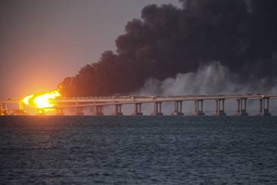 Flame and smoke rise from Crimean Bridge connecting Russian mainland and Crimean peninsula over the Kerch Strait, in Kerch, Crimea, Saturday, Oct. 8, 2022.
