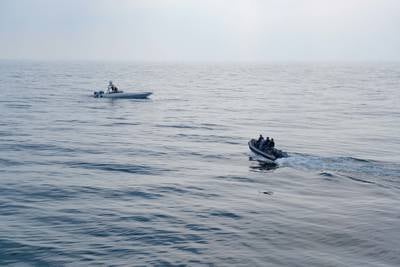 Members of Combined Task Force 152 operate a small boat near a MARTAC T-38 Devil Ray unmanned surface vessel in the Arabian Gulf.