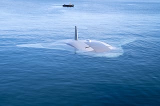 Northrop Grumman's Manta Ray unmanned underwater vehicle is seen during at-sea testing in 2024. A person can be seen in a boat behind it.