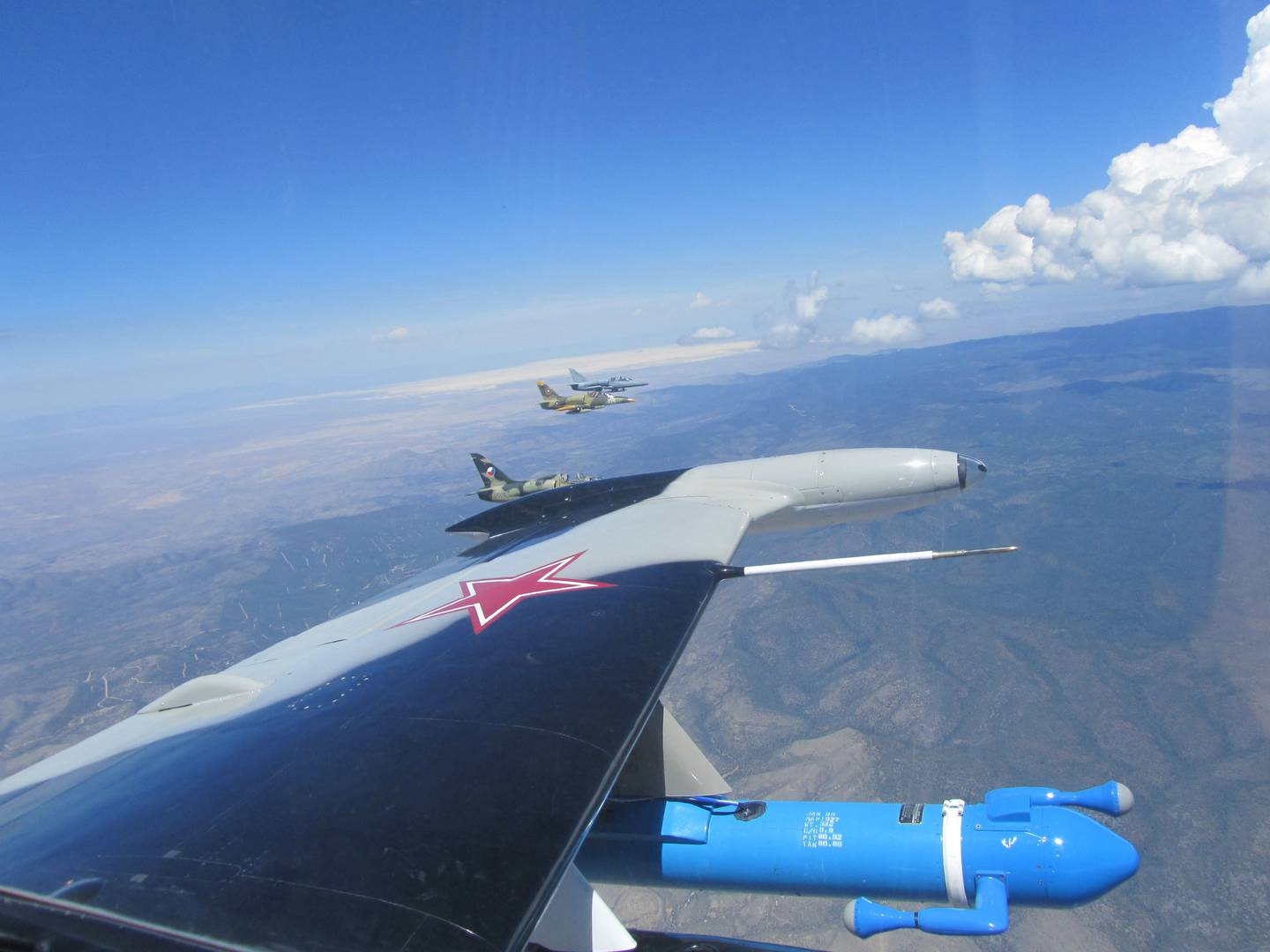 Georgia Tech Research Institute next-generation electronic warfare equipment — carried in a bright blue pod at the bottom of the photo — being flight-tested aboard an L-39 Albatros jet trainer aircraft.