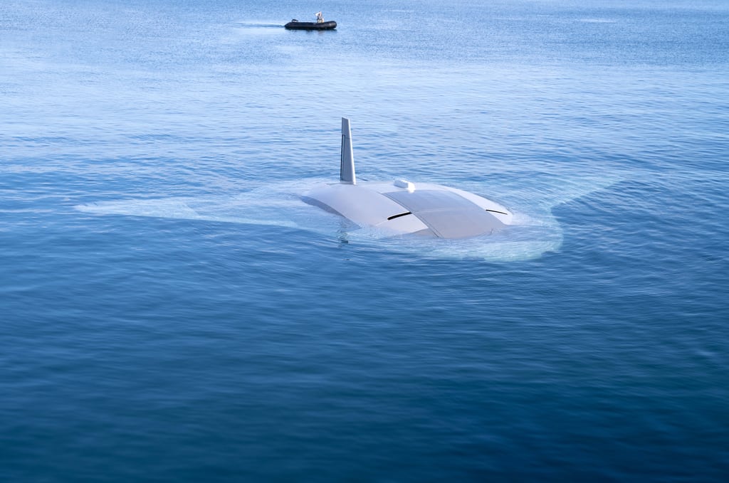 Northrop Grumman's Manta Ray unmanned underwater vehicle is seen during at-sea testing in 2024. A person can be seen in a boat behind it.