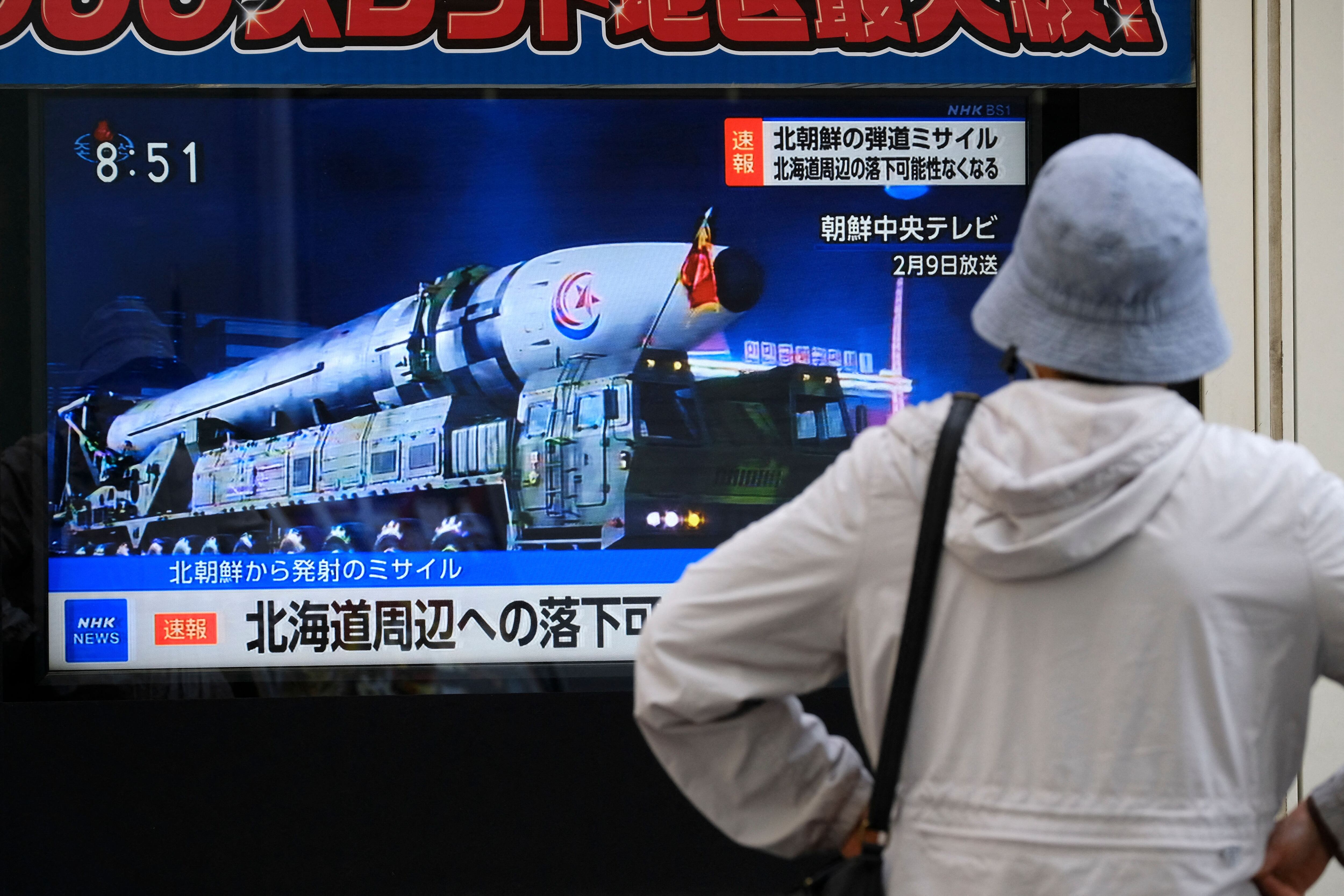 A woman in Tokyo, Japan, watches a television broadcasting breaking news of a North Korean missile launch.