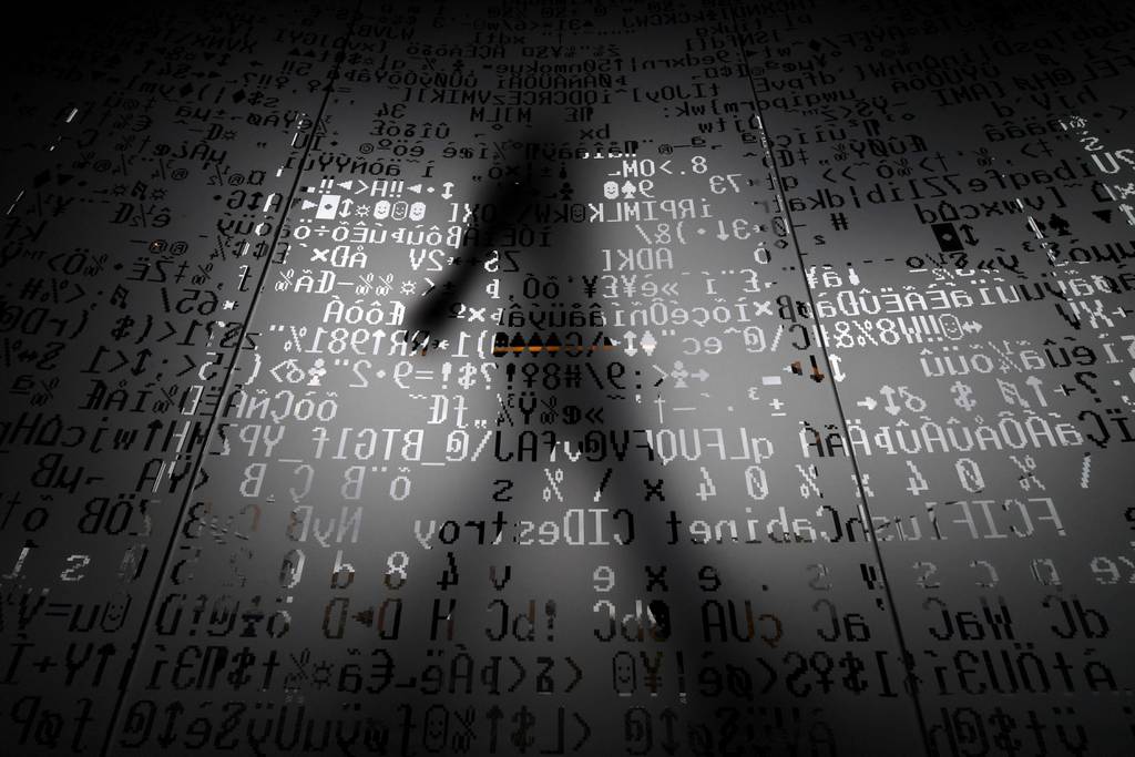 A picture taken on Oct. 17, 2016, shows an employee walking behind a glass wall with machine coding symbols at the headquarters of internet-security giant Kaspersky in Moscow.